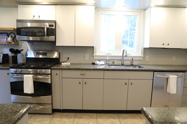 Kitchen showing toaster oven, tea kettle, stove, microwave, sink, and dishwasher