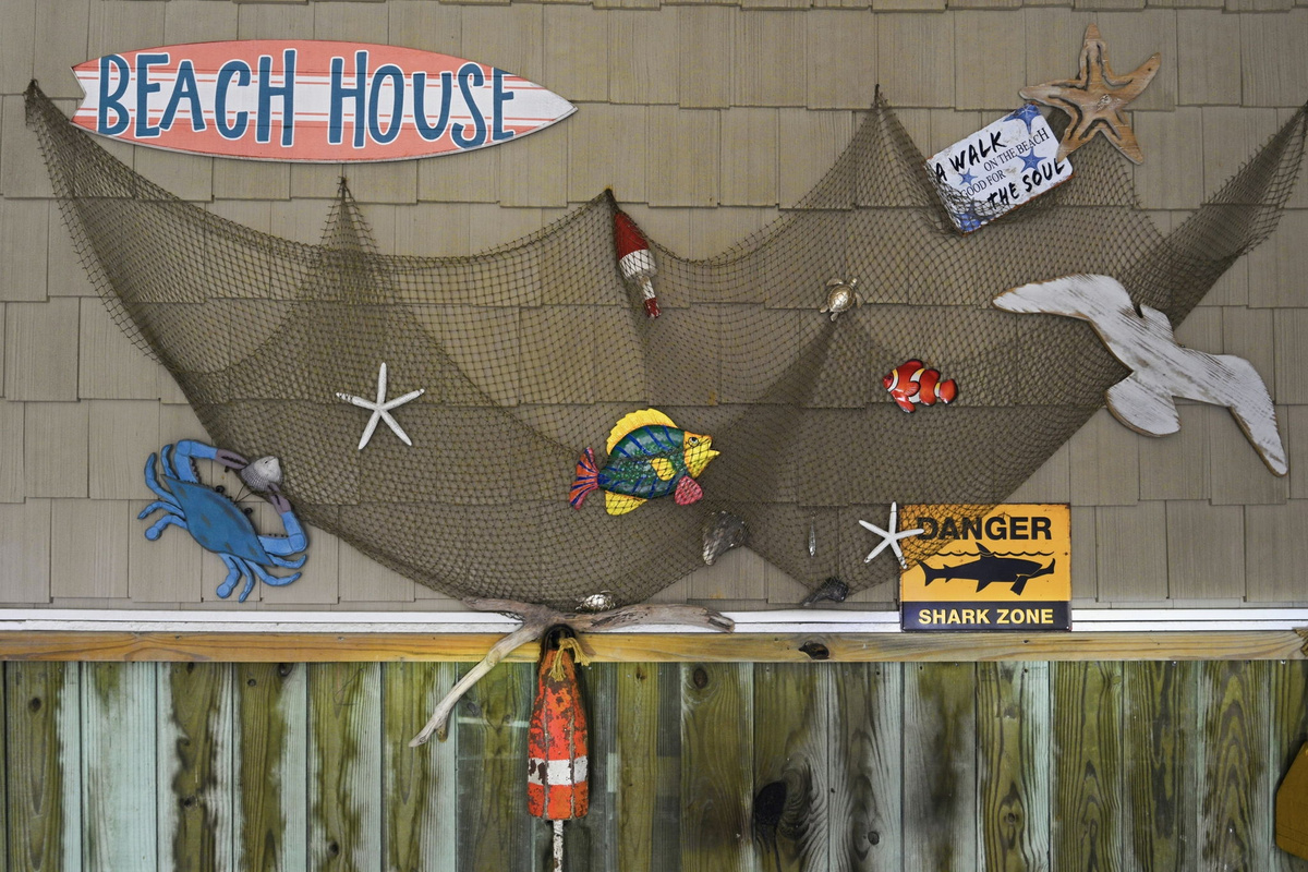 Nautical wall display with fishing net art and coastal themed signage
