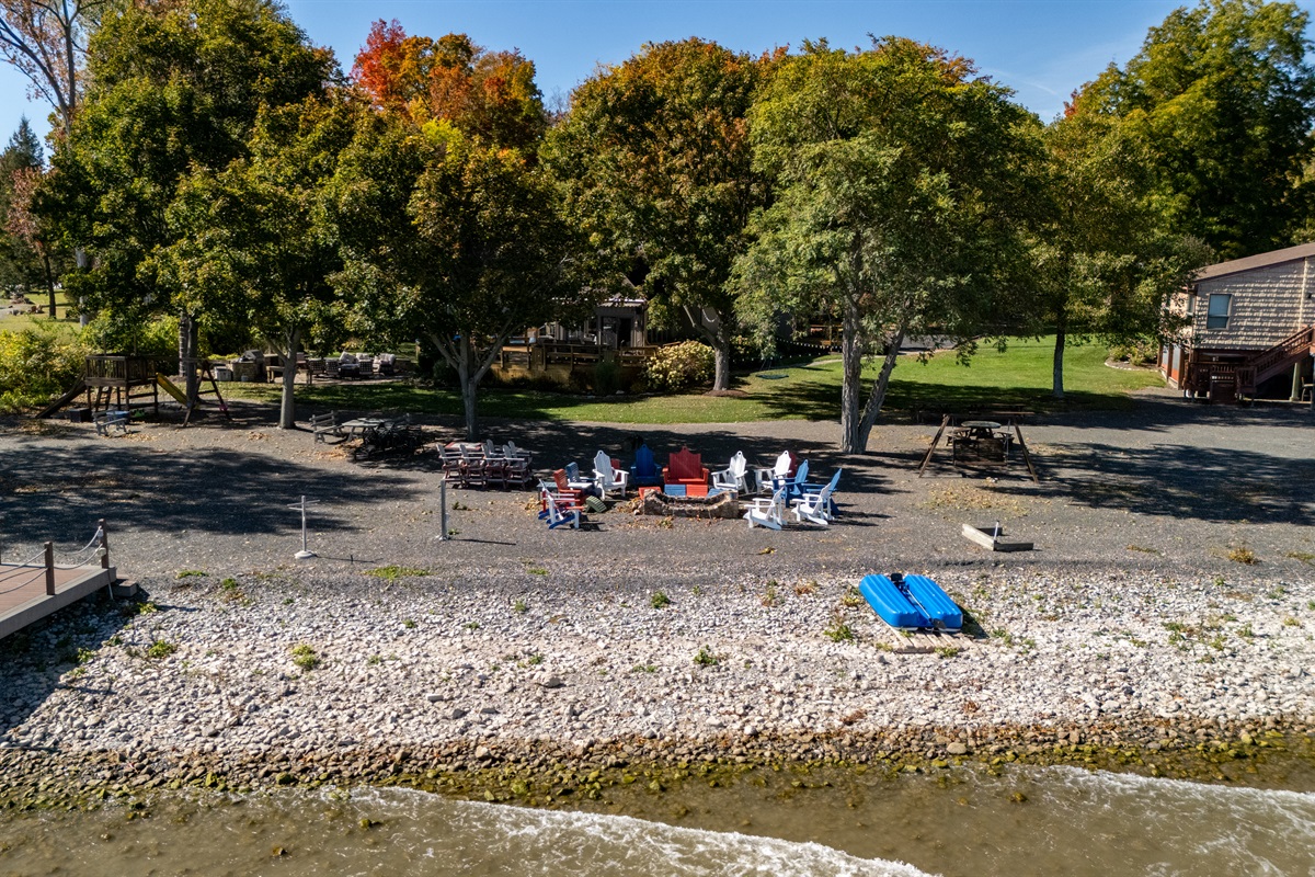Relax on your private lakeside shoreline with cozy Adirondack seating and calm waterfront views.