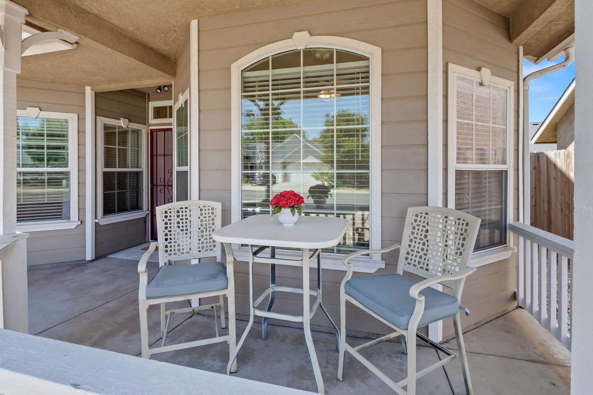 Enjoy the comfort of outdoor living with a private covered porch and bistro-style seating. This welcoming space provides a relaxing extension of the home, perfect for unwinding at any time of day.