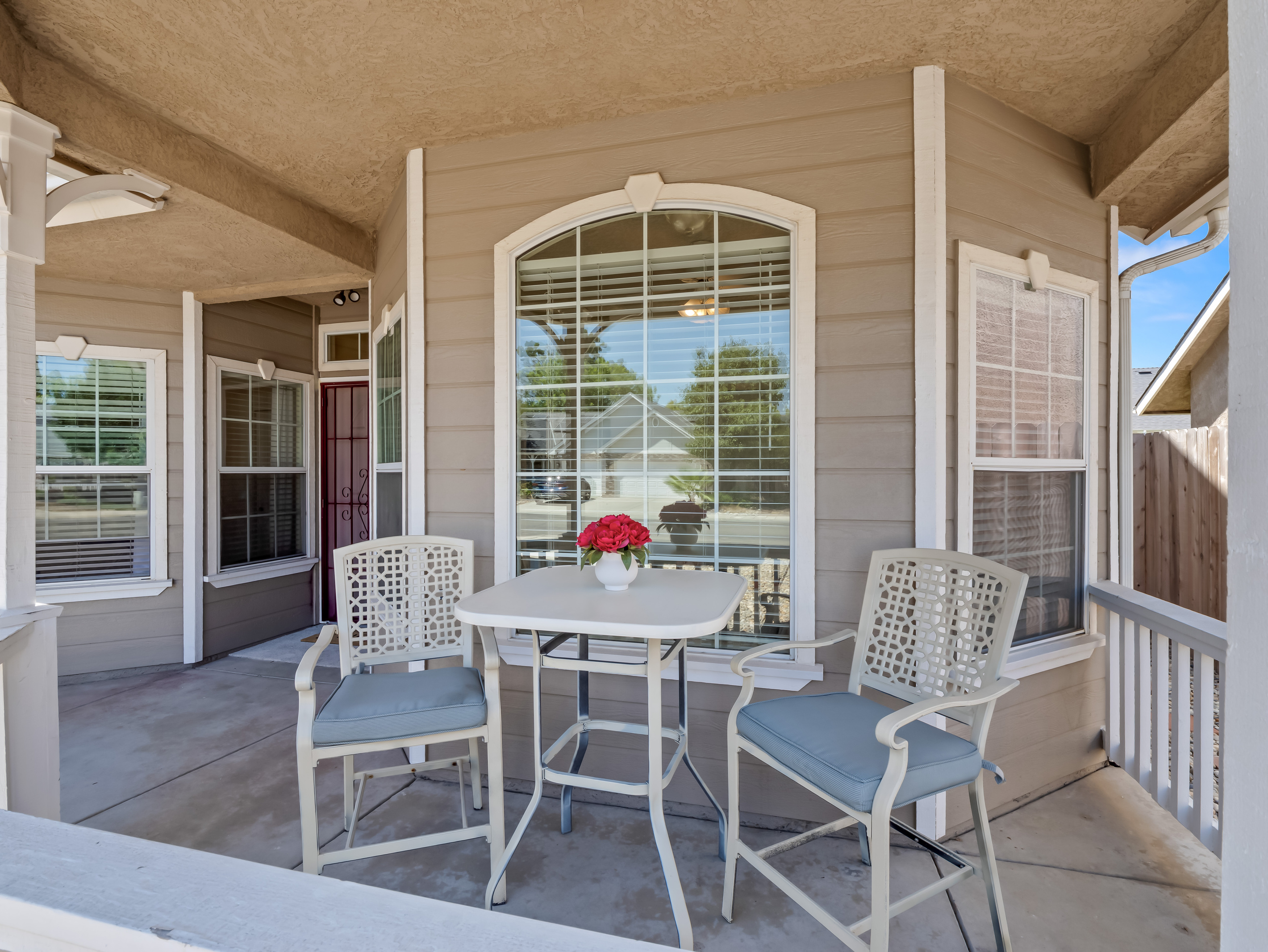 Enjoy the comfort of outdoor living with a private covered porch and bistro-style seating. This welcoming space provides a relaxing extension of the home, perfect for unwinding at any time of day.