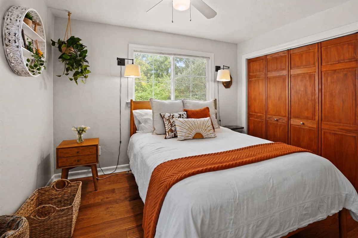 A basket is provided for extra bed pillows, and the room includes a ceiling fan for added comfort.