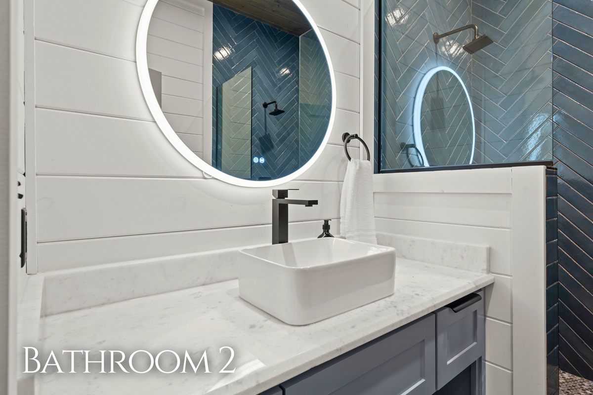 Clean lines, bright lighting, and a stylish vanity bring both function and modern charm to this thoughtfully designed bathroom space.