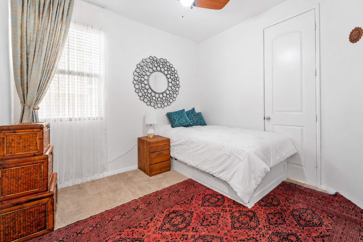 Small bedroom with a cozy bed, soft curtains, and a simple place to rest.