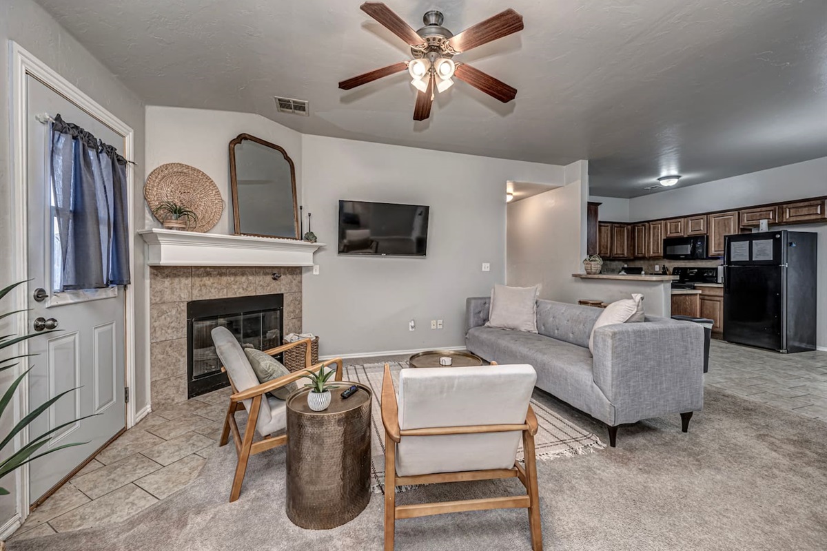 Spacious living area featuring comfortable seating, smart TV, and a warm fireplace.
