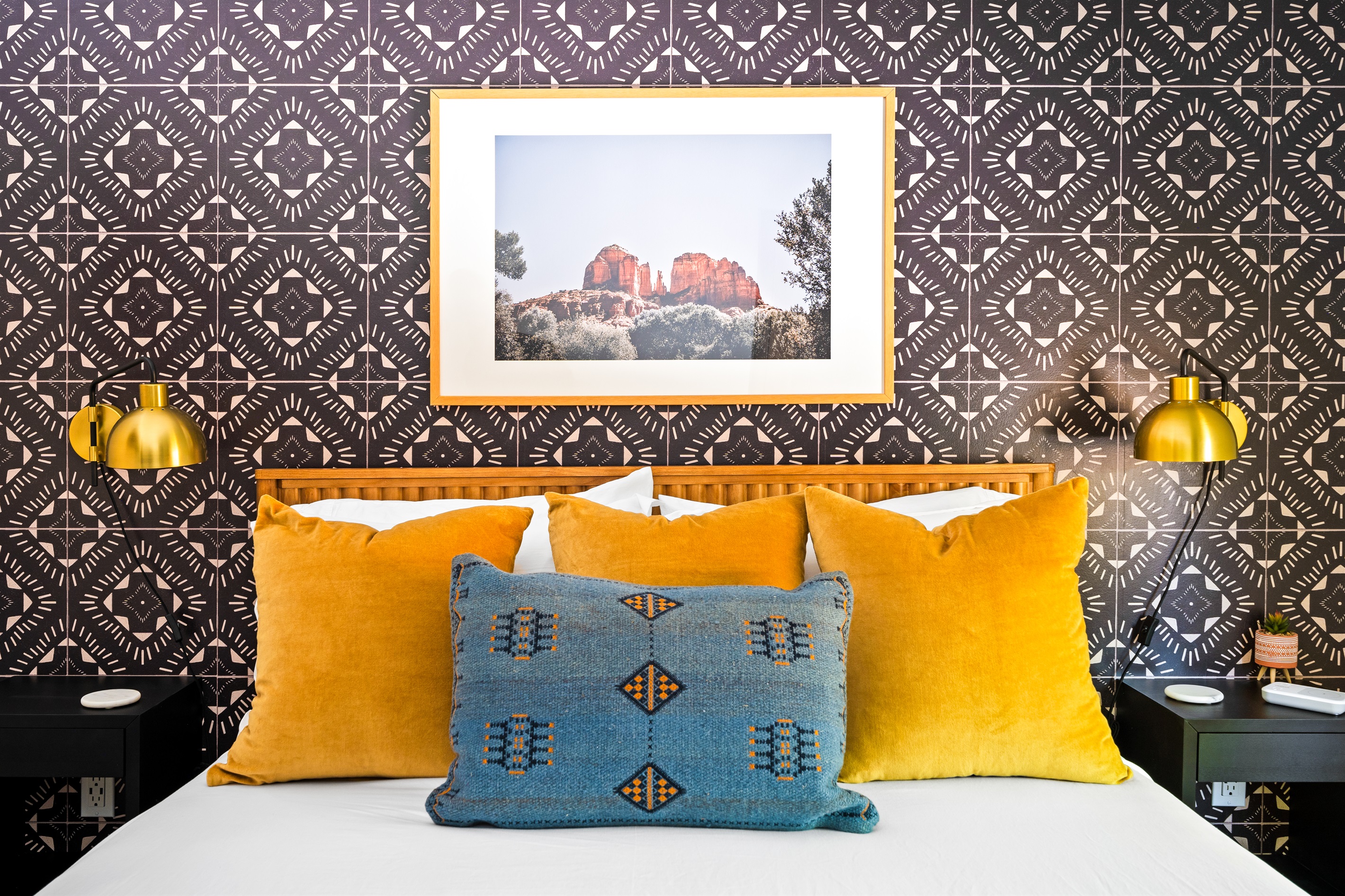 Inviting queen bedroom featuring colorful accents, plush pillows, and beautiful Cathedral Rock Sedona art.