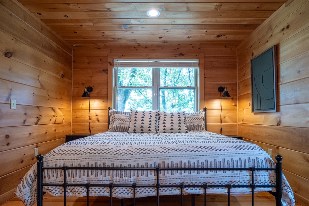 Wake up to beautiful views and natural light in this serene primary bedroom, designed for your utmost comfort.