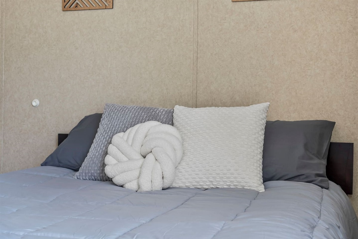Detailed view of layered pillows and soft bedding, adding a warm and welcoming touch to the room.