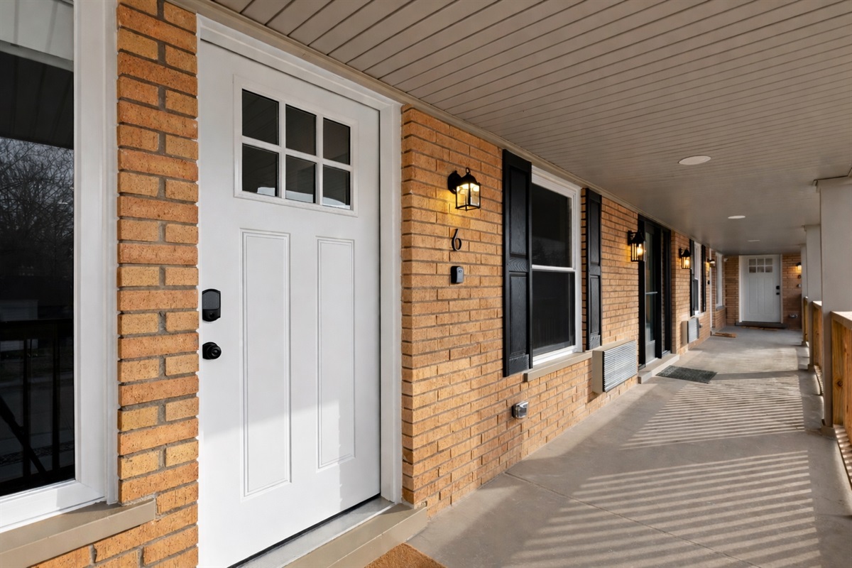 Welcoming private entrance with covered walkway and exterior lighting—easy access, added privacy, and a great first impression.