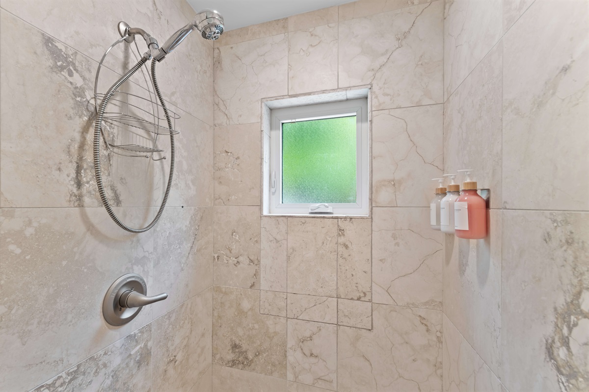 Spacious guest bath with clean finishes, hair dryer, walk in shower, and plenty of counter space.