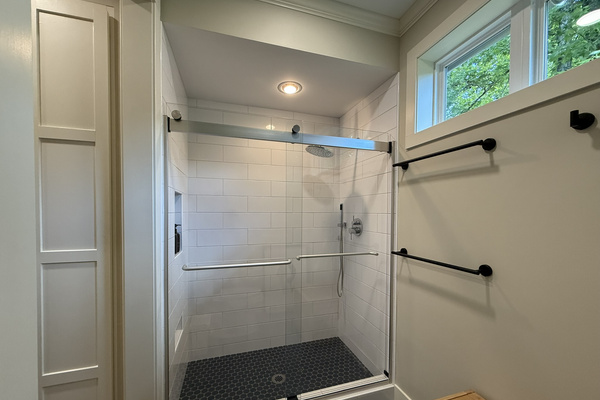 Master bath walk-in shower with glass doors and modern tile finishes