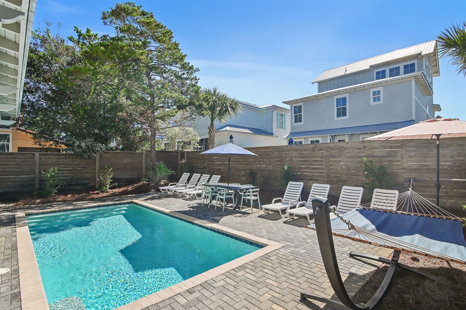 The private pool area features lounges, poolside tables and chairs, a hammock, and a grill.