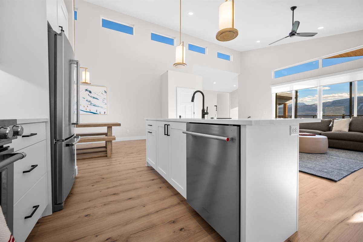 Kitchen island with built-in dishwasher and open sightlines to the living and dining rooms.