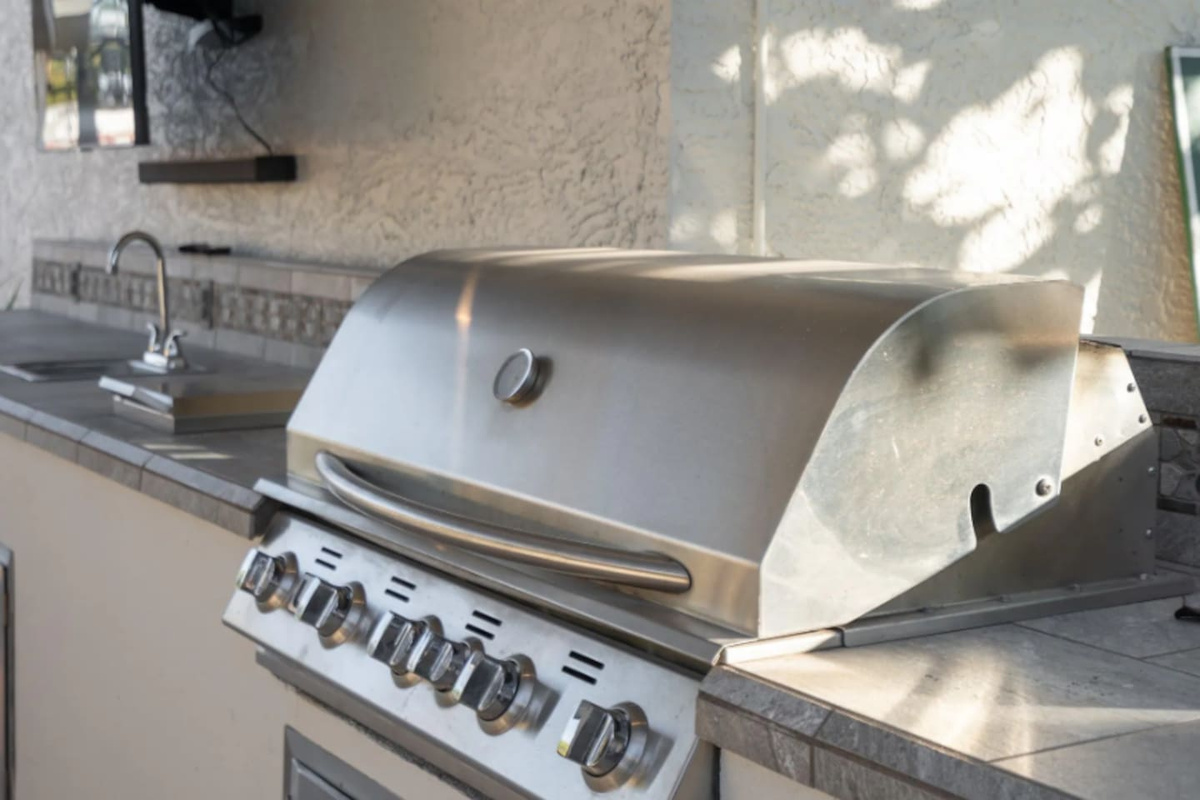 A commercial-grade grill anchors the outdoor kitchen, ready for a group cookout at any hour.
