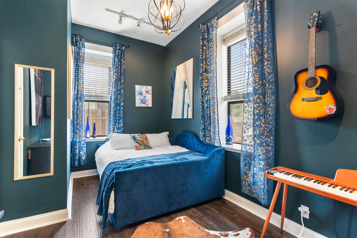 A bedroom with a little rhythm on the main level with bold color, original art and plenty of personality.
