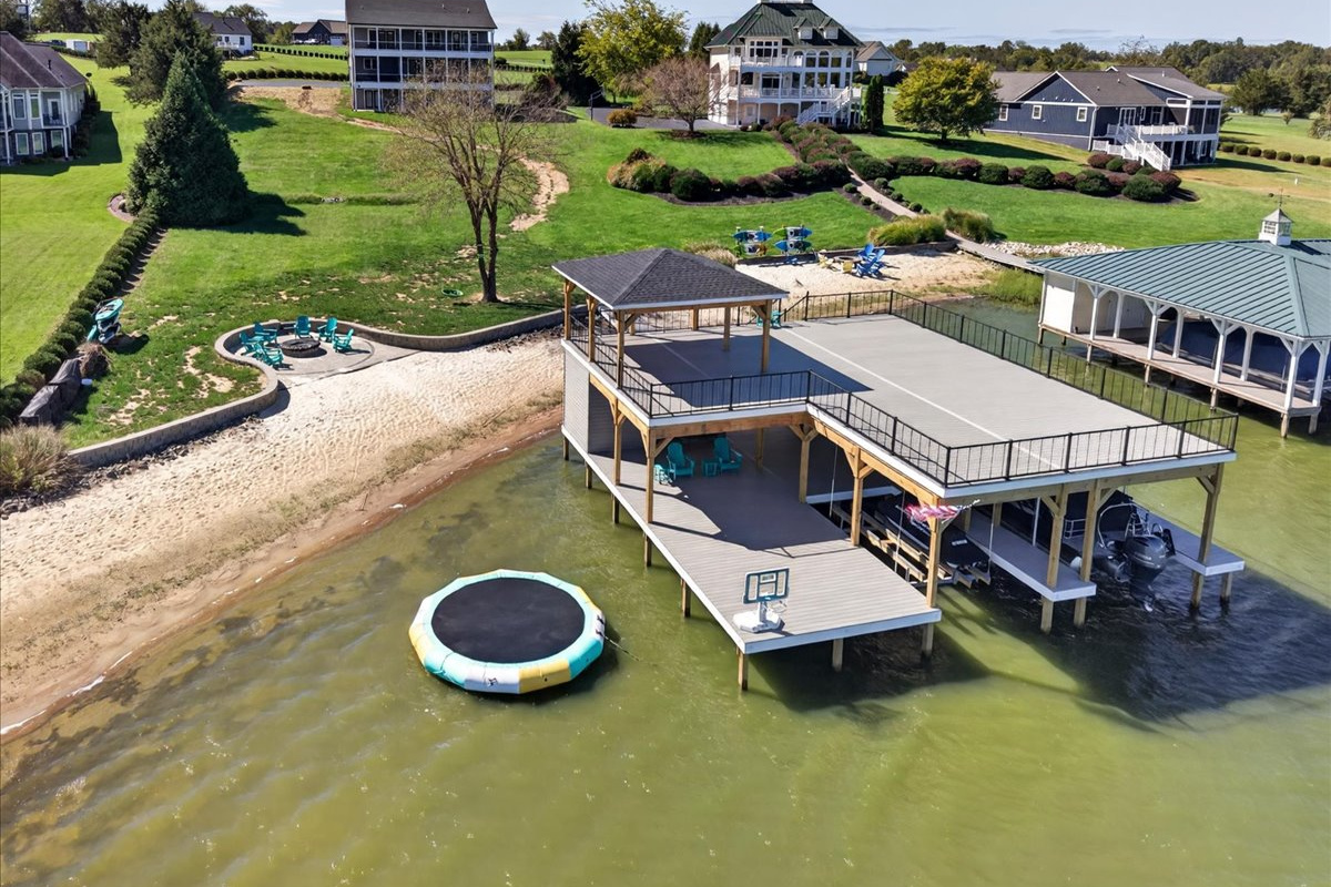 Boathouse, sandy beach, waterfront firepit, and water trampoline make the shoreline a destination of its own.