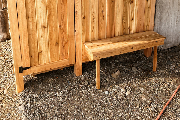 Outdoor shower with a convenient bench provides an easy spot to rinse off and refresh after the beach.