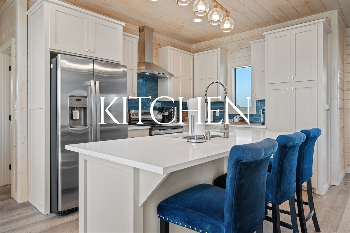 Modern kitchen with stainless appliances, spacious island, and seating for casual dining.