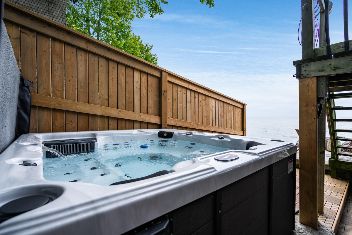 Private hot tub on a spacious deck surrounded by natural wood fencing.
