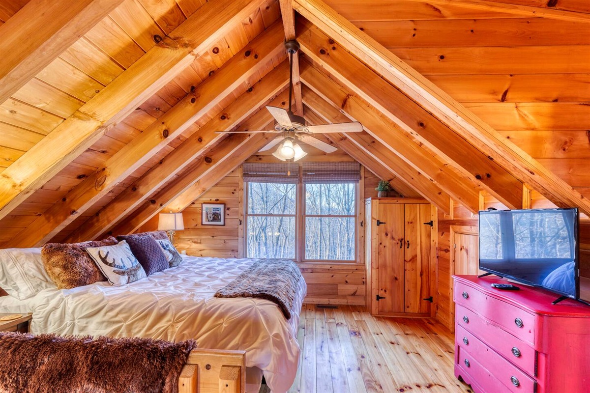 King bed in the loft with TV also has an adjacent to private bath