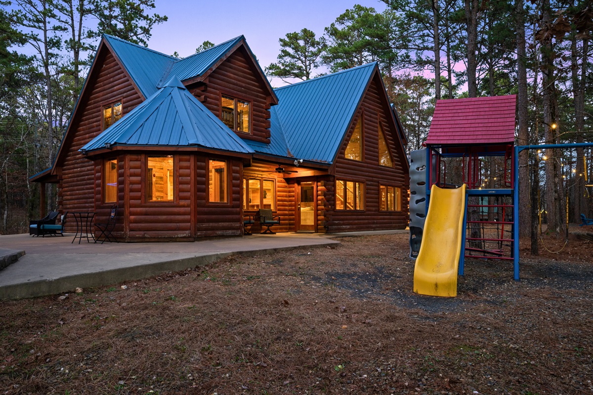 This exterior view showcases the classic log cabin style, blending naturally into the surrounding forest setting.