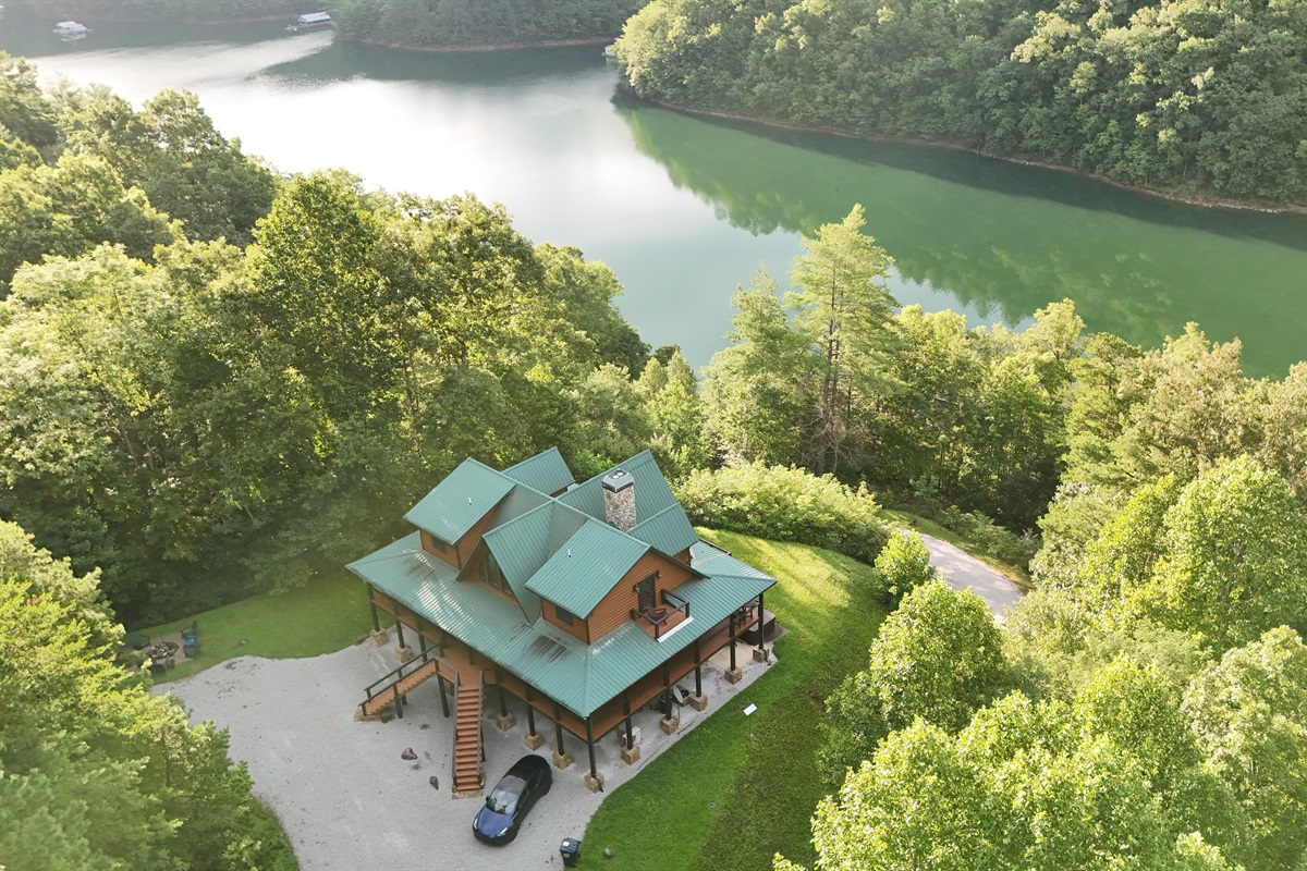 Nature's embrace. This stunning home is perfectly situated amidst the lush greenery of the mountains.