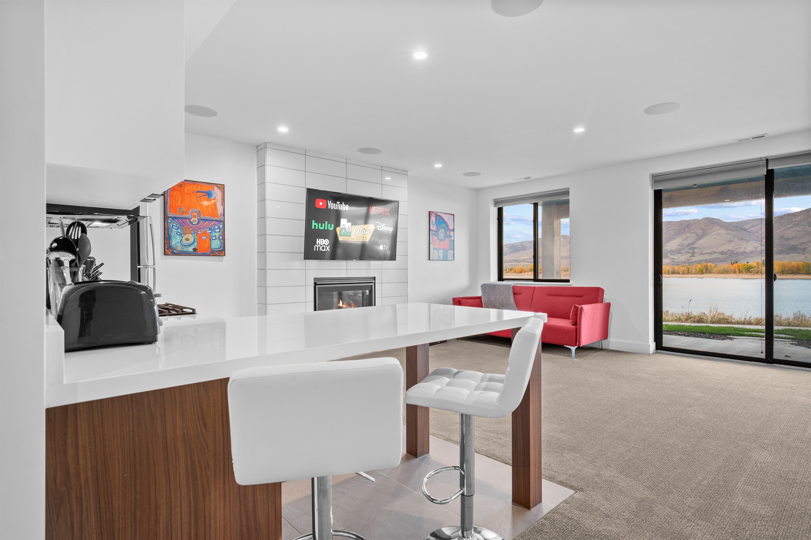 Open-concept lower-level kitchen and living area with Smart TV, fireplace. & views.