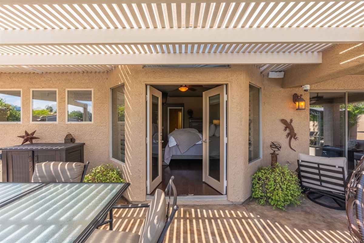 The French doors from the primary bedroom open directly onto the patio — roll out of bed, step outside, and start your morning with fresh air and lake views before the day even begins.