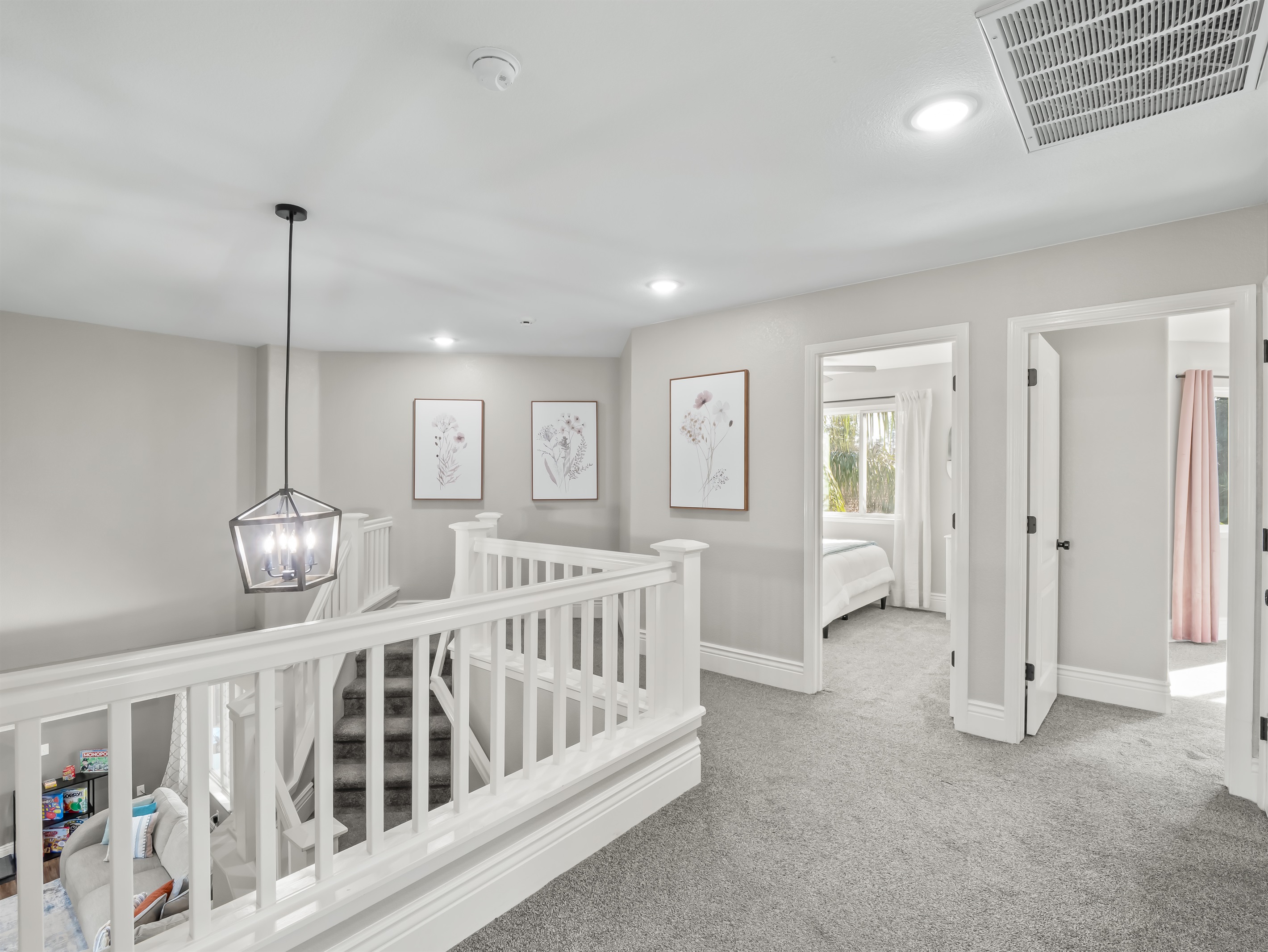 Light-filled upper-level corridor with elegant railing, designer lighting, and soft neutral tones—enhancing the home’s open layout and upscale feel.