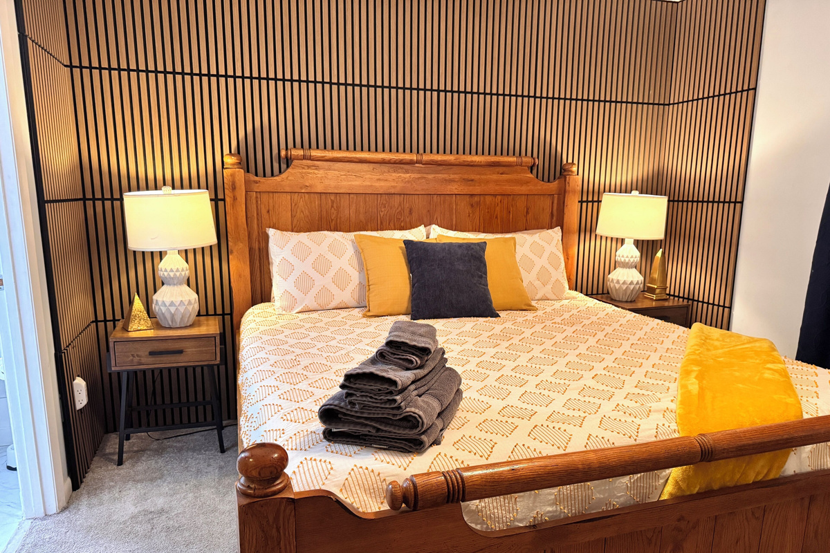 Primary bedroom: king bed with wood-slat accent wall