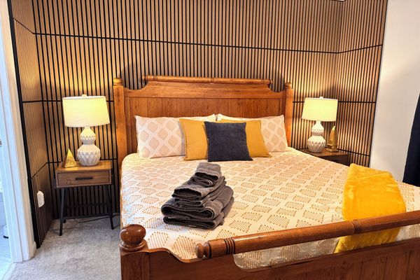 Bedroom 1: king bed with wood-slat accent wall