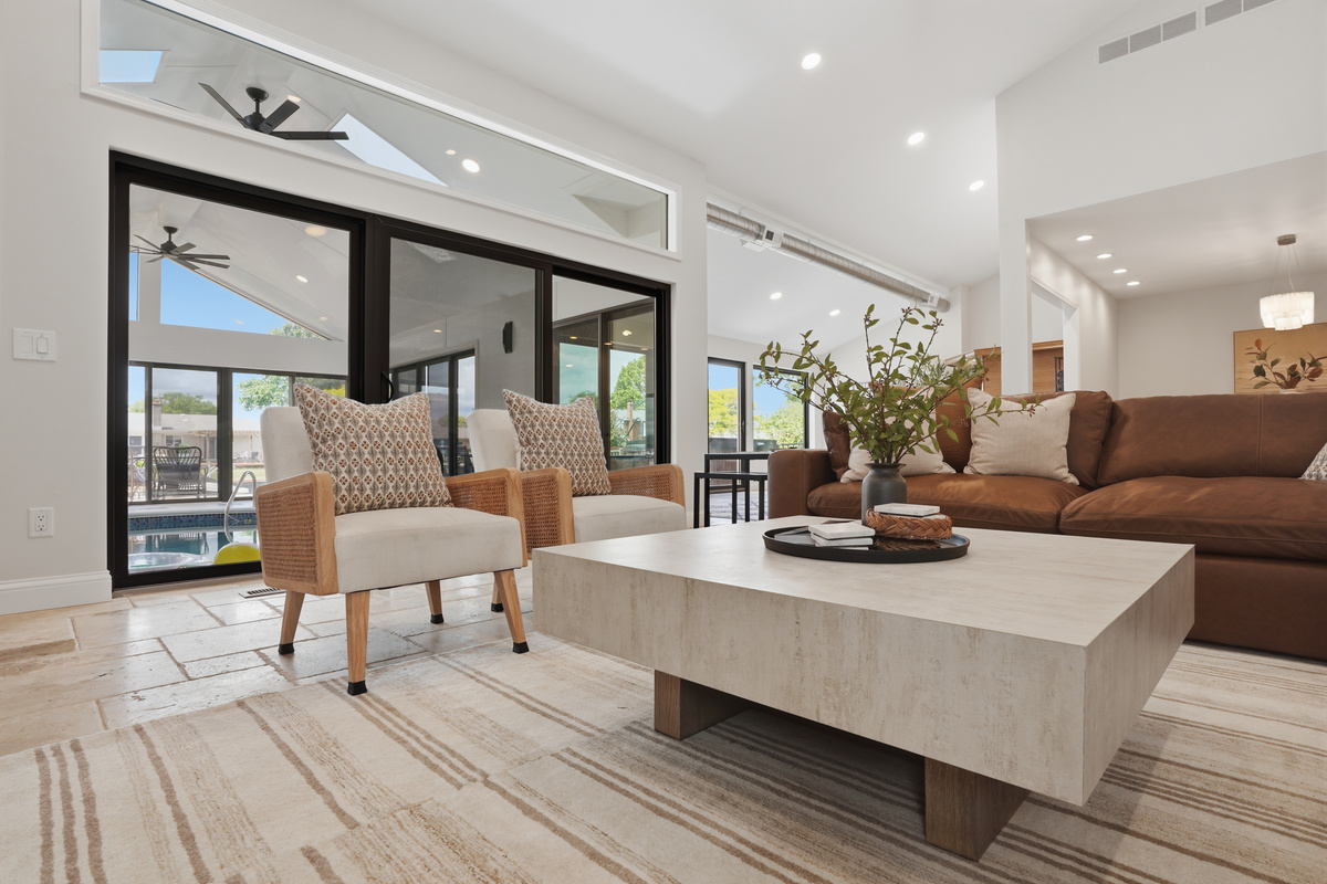 Relax in the bright and inviting living area, featuring comfortable seating, modern design, and seamless access to the indoor pool and outdoor spaces.