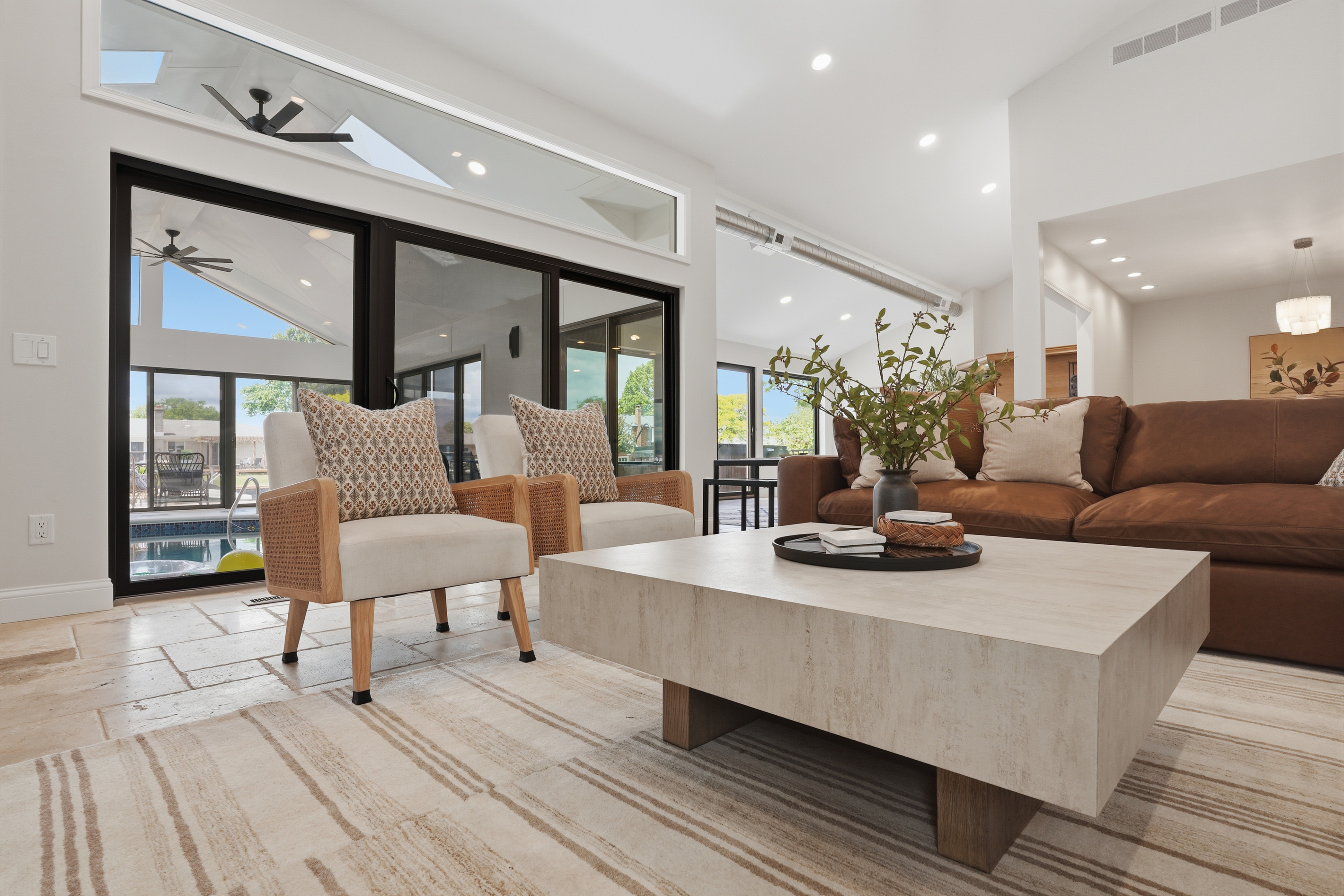 Relax in the bright and inviting living area, featuring comfortable seating, modern design, and seamless access to the indoor pool and outdoor spaces.