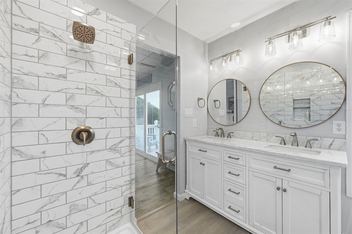 Enjoy a sleek, glass-enclosed shower that feels bright, modern, and spa-like—perfect for refreshing after a day at the beach.