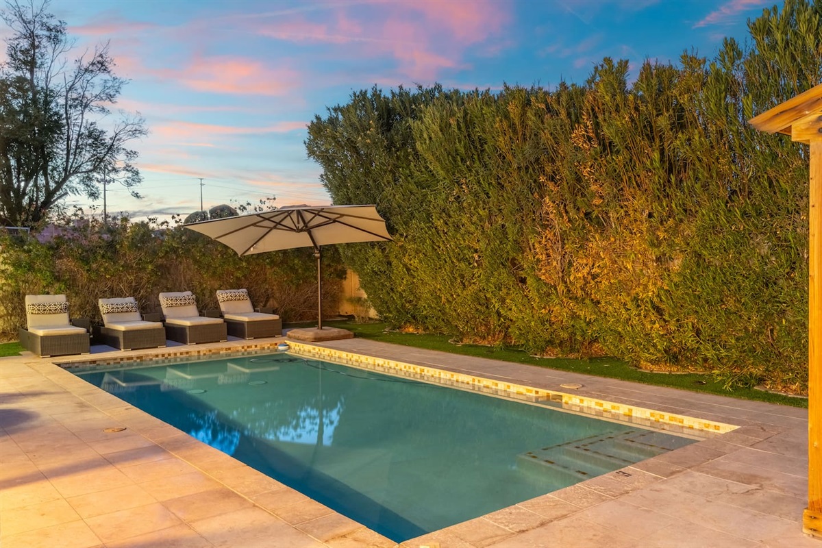 Relax on one of the cushioned loungers beneath the oversized umbrella, with evening skies painting the perfect backdrop.