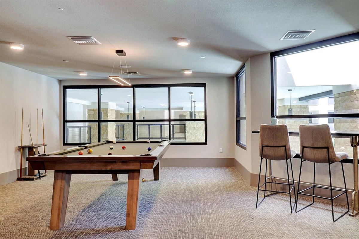 - Enjoy a modern game room with a sleek pool table and comfortable seating   - Floor-to-ceiling windows bring in natural light and relaxing views   - Perfect for friendly games and fun evenings during your stay
