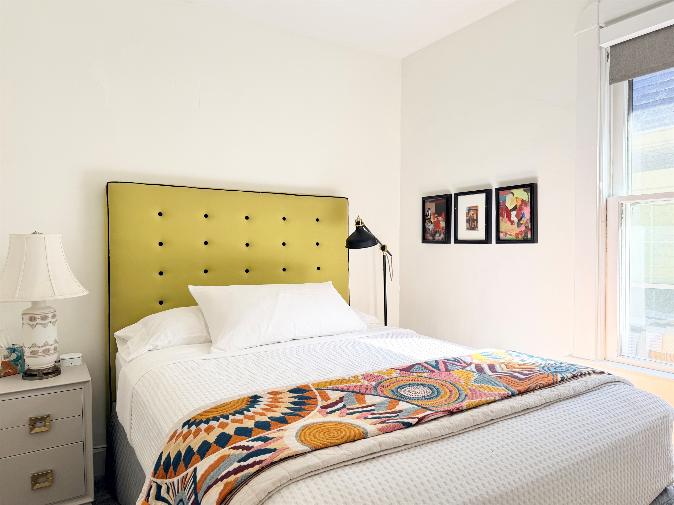 Queen bed with luxury cotton linens, plush mattress, blackout shades, bedside table, soft lighting, ceiling fan & wireless charging station — our quietest room for deep, restful sleep