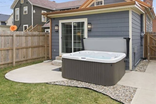 Private outdoor space with hot tub and fenced yard for added comfort and privacy