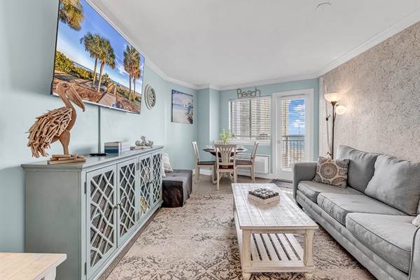 Spacious living room with 65-inch flat-screen TV, comfortable sofa, and coastal décor