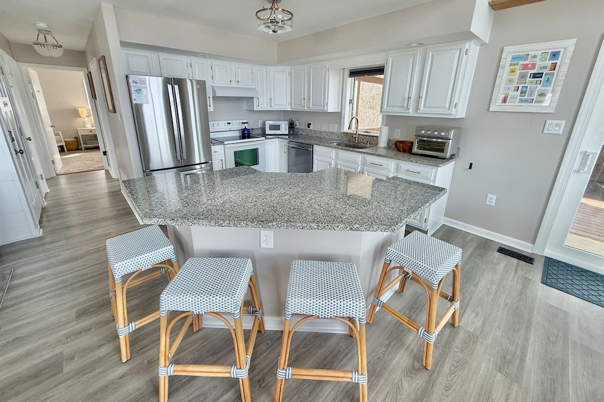 Gather around this modern kitchen island for coffee and conversation. It is the perfect, inviting hub for friends and family to relax and enjoy a memorable vacation together.