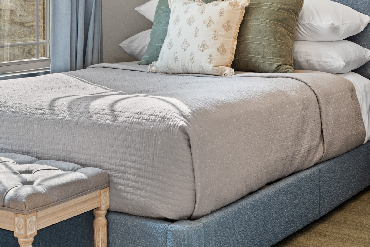 Soft greens and a blue upholstered bed keep the Austin Twin Room bright and restful.