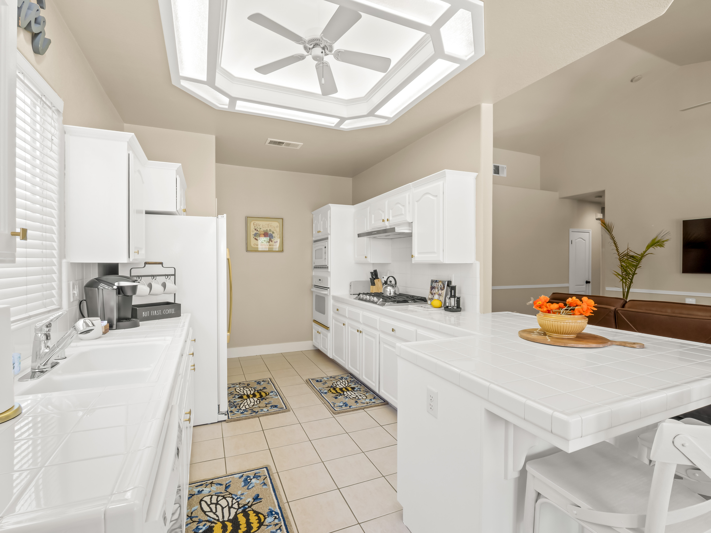 This spacious kitchen features ample cabinetry, extensive countertop space, full-size appliances, and a large island with seating.