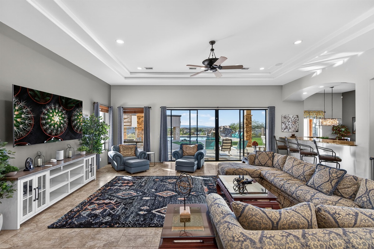Expansive great room with oversized seating and seamless pool-view access — perfect for gathering after a day of exploring Phoenix