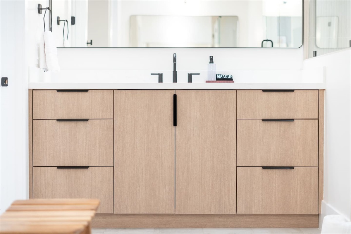 Double vanity with natural wood cabinetry and ample storage.