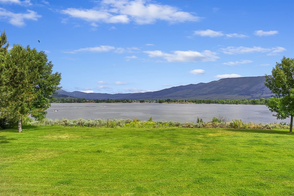 Expansive lawn leading to stunning lake and mountain views.