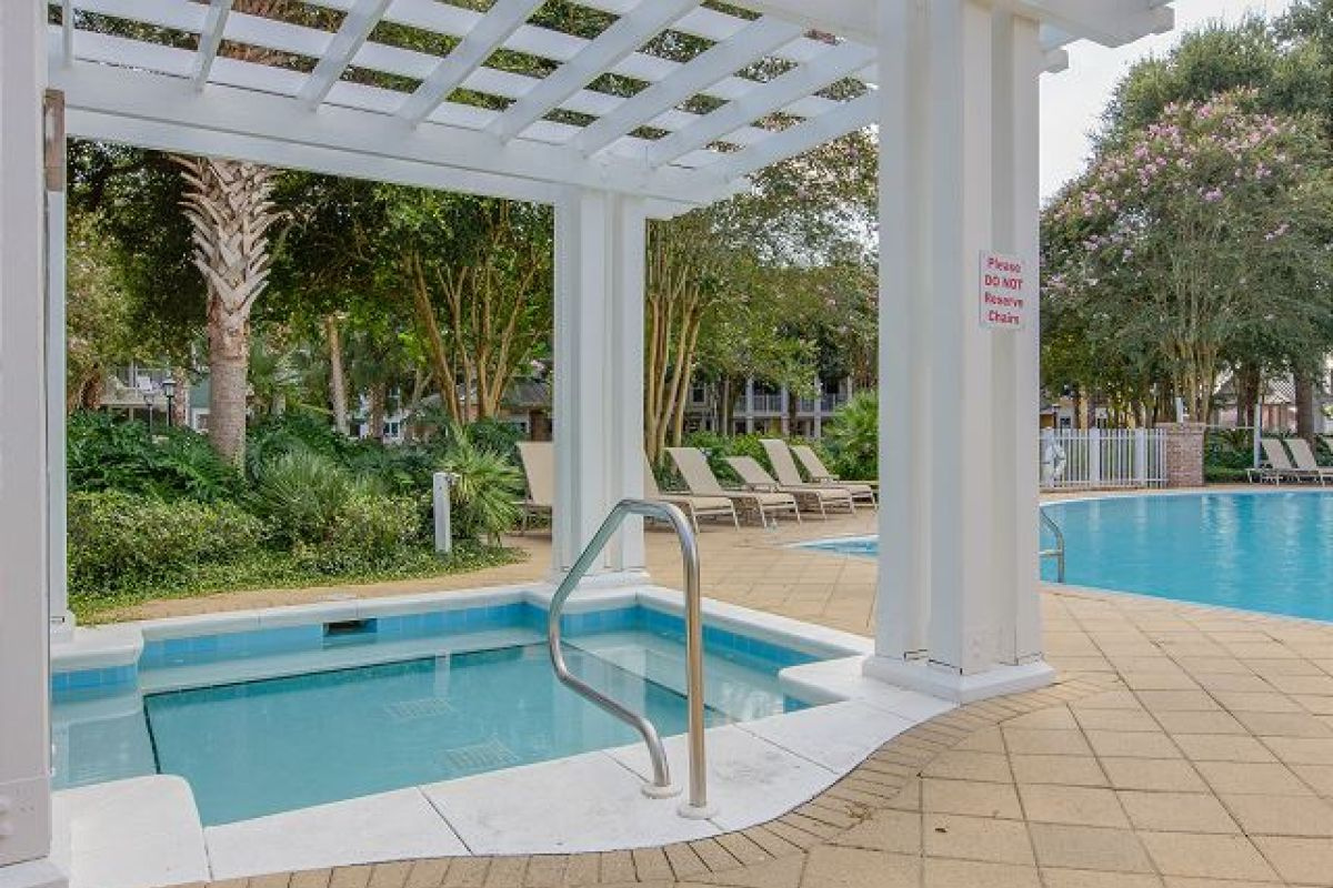 Hot tub under a white pergola beside the Pilot House pool and lounge chairs