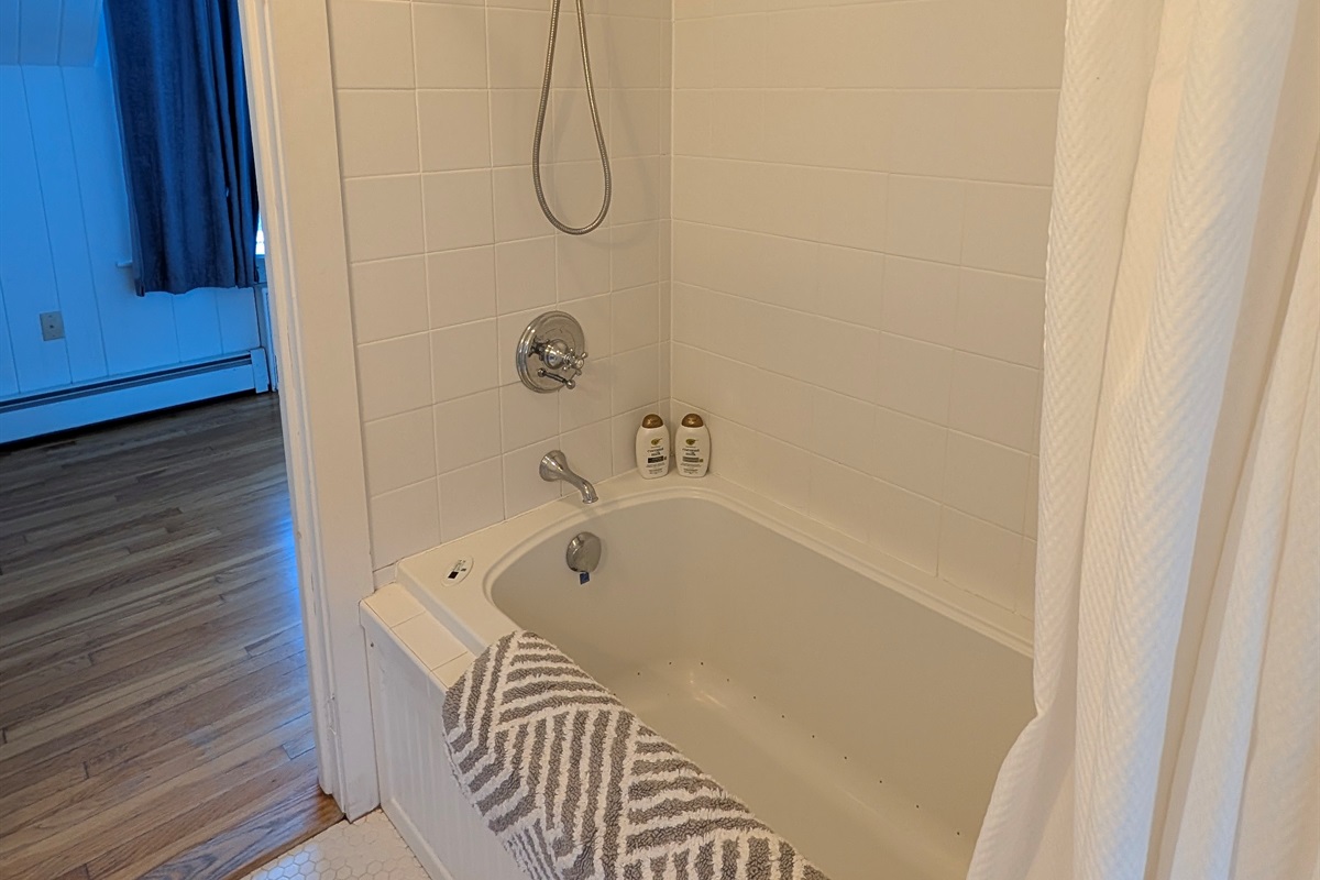 Second full bath featuring a classic tub and tile surround, reflecting the home’s timeless farmhouse character.