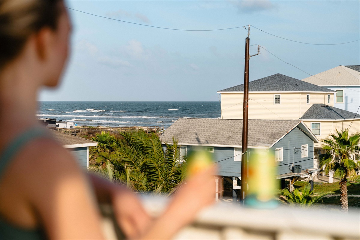 Drink in hand, Gulf in view — the math of every vacation day.