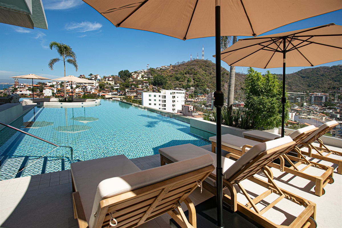 Dive into the rooftop infinity pool—an unmatched spot to relax above the Romantic Zone with sweeping mountain and city views.