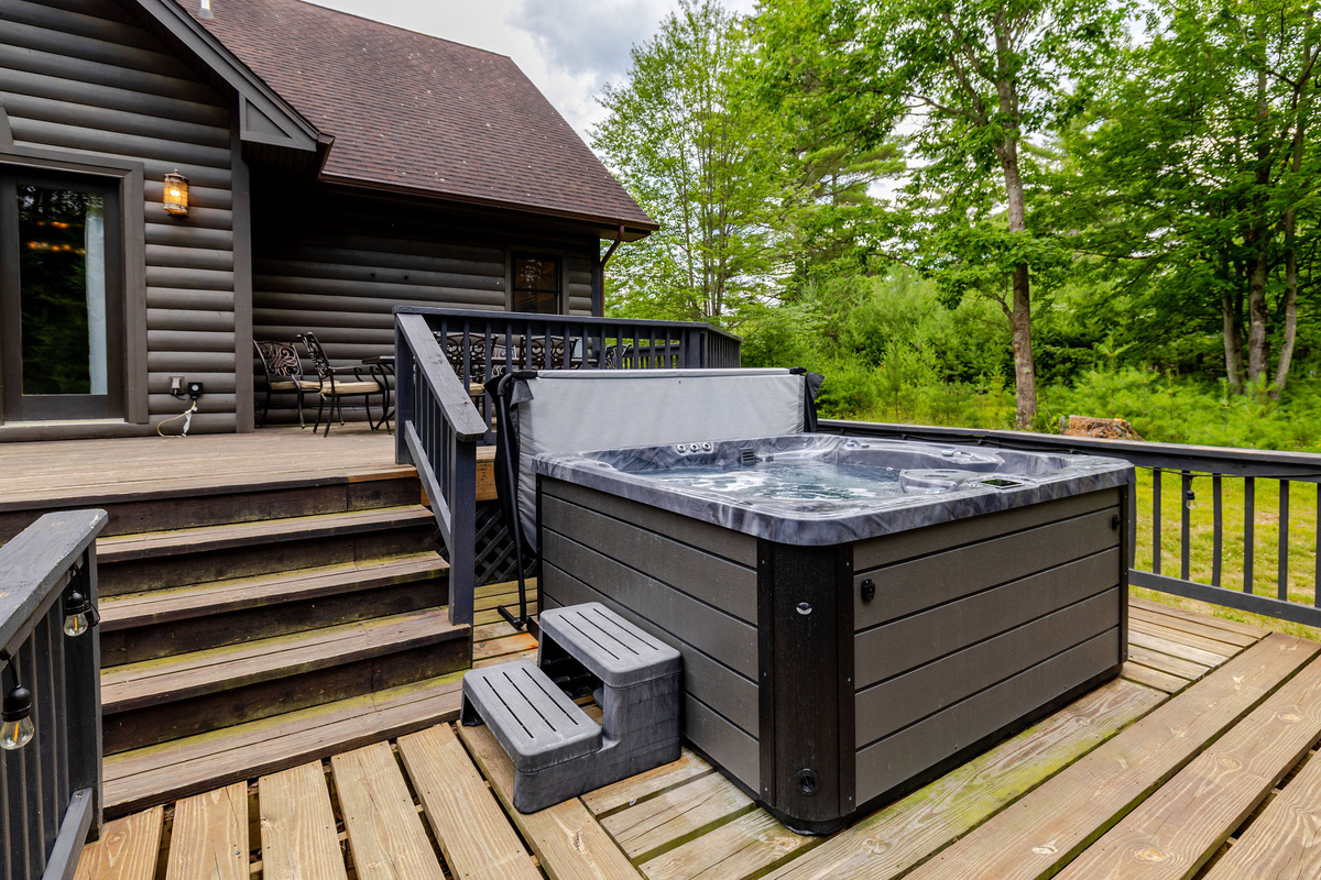 Soak in the private hot tub surrounded by peaceful forest views—the perfect way to unwind after a day of hiking, skiing, or exploring the Adirondacks.